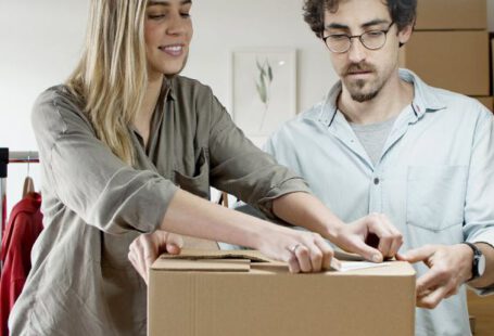 Packing Light - Woman Putting the Sticker on the Box