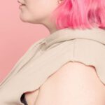 Body Type - Serious young plus size woman in pink studio