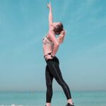 Fit - Woman Pointing at Sky on Seashore