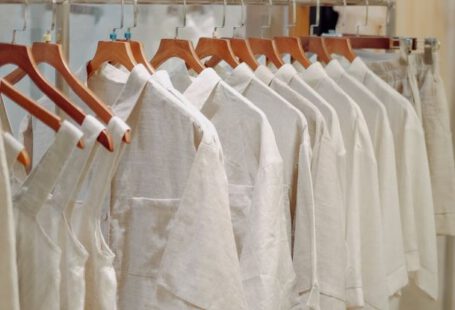 Wardrobe Basics - Clothes in Neutral Colors Hanging on the Racks in a Clothing Store