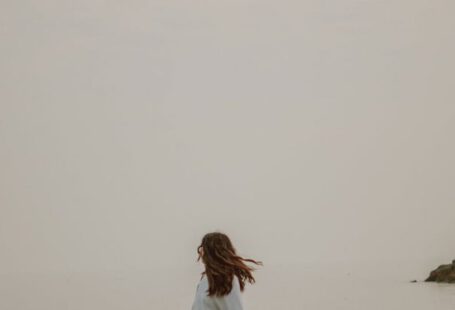 Weekend Style - Anonymous tourist admiring sea from stone in misty weather