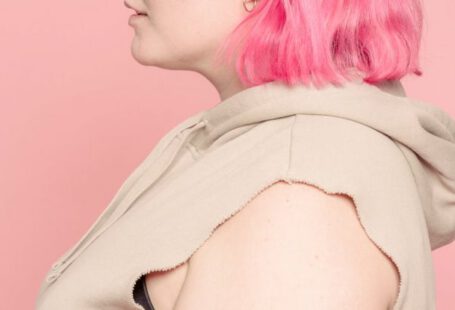 Body Type - Serious young plus size woman in pink studio