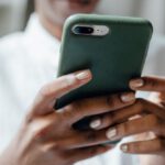 Casual Look - Black woman messaging on modern cellphone