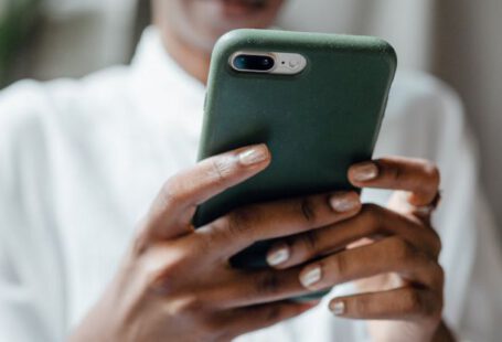 Casual Look - Black woman messaging on modern cellphone