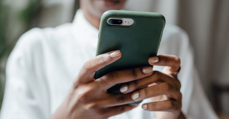 Casual Look - Black woman messaging on modern cellphone