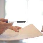 Negotiation - Crop businessman giving contract to woman to sign