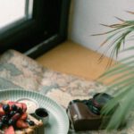 Vintage Items - Photo of a Piece of Cake, Coffee and an Analog Camera Spread Out on a Map