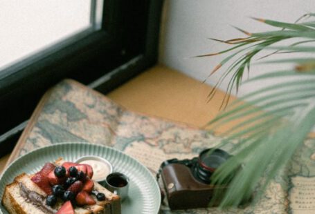 Vintage Items - Photo of a Piece of Cake, Coffee and an Analog Camera Spread Out on a Map