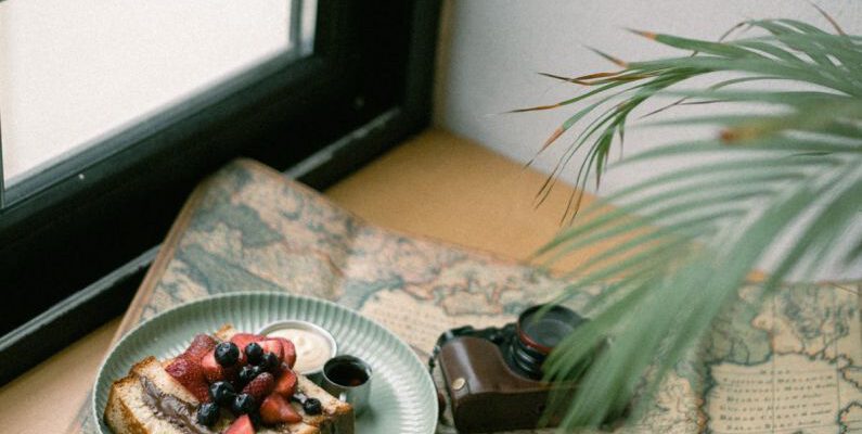 Vintage Items - Photo of a Piece of Cake, Coffee and an Analog Camera Spread Out on a Map