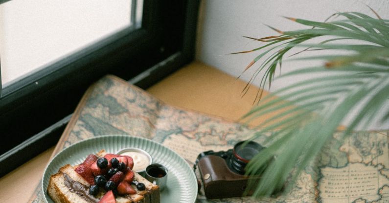 Vintage Items - Photo of a Piece of Cake, Coffee and an Analog Camera Spread Out on a Map