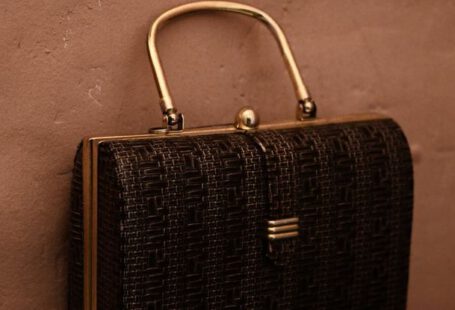 Vintage Trend - Vintage bag with golden handle placed on reflecting surface as accessory for garment