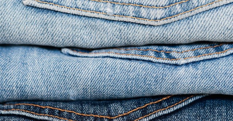 Quality Denim - Stack of blue jeans arranged by color