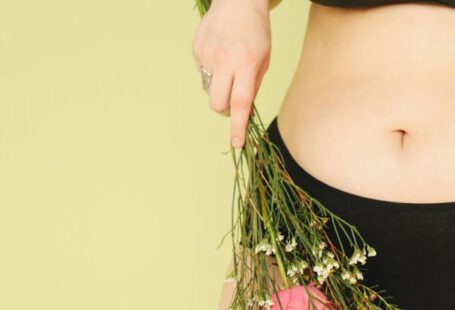 Undergarments - A Woman Wearing Black Undergarments Holding Stems of Flower