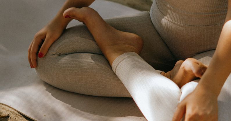 Activewear - A Woman in Activewear Sitting on a Yoga Mat