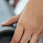 Workout Motivation - Crop female holding rolled mat on floor