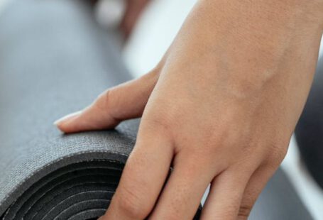 Workout Motivation - Crop female holding rolled mat on floor