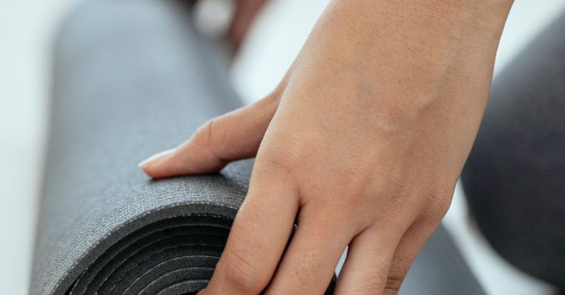 Workout Motivation - Crop female holding rolled mat on floor